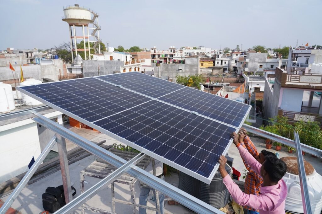 Community members installing solar panels on a rooftop in a small village.